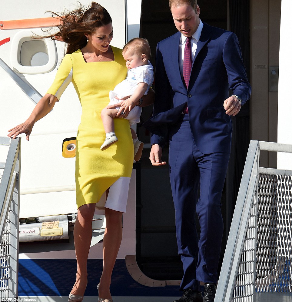 Wake up: Kate peers down at a sleepy Prince George as she steps off the plane in her Roksanda Ilincic dress