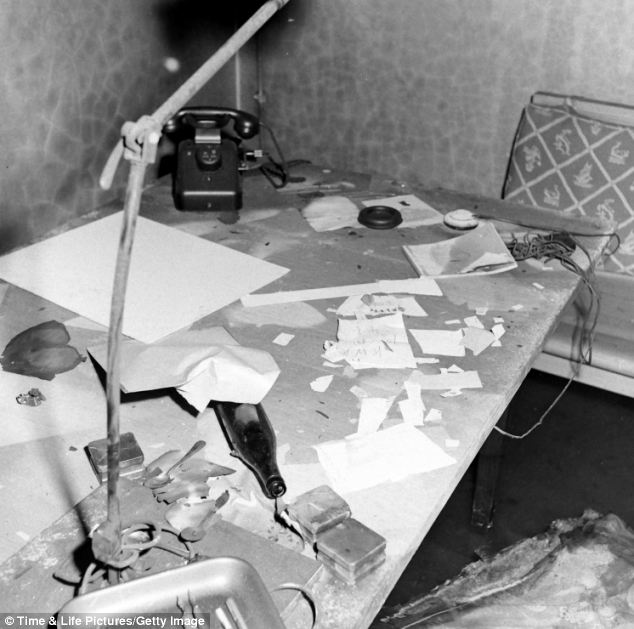 Debris lies scatted on a make-shift desk near to the sofa. Photographer William Vandivert was the first western man to gain access to the disturbing bunker two weeks after Hitler's death
