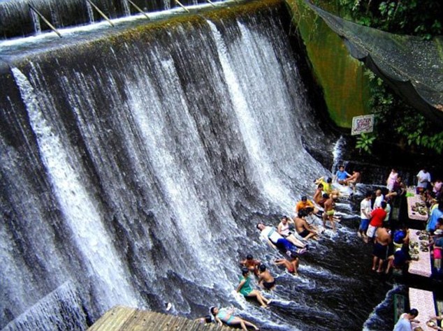 An after lunch lie down: Customers cool off in the rushing waters in Villa Escudero's Waterfalls Restaurant