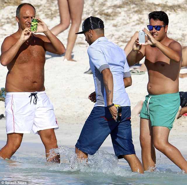 Snapped: Fans stop to take pics of the superstar as he walks past