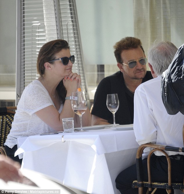 Fine dining: Bono and his friends chat intently as they enjoy an al fresco lunch in London on Friday