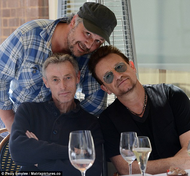 New pals: After sharing a bottle of rose with the snappers, Bono poses for a photograph with the pair