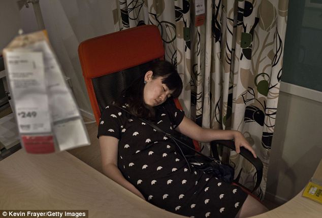 Run out of beds? A woman takes her nap on a high-backed swivel chair in one of the shop's mocked-up rooms