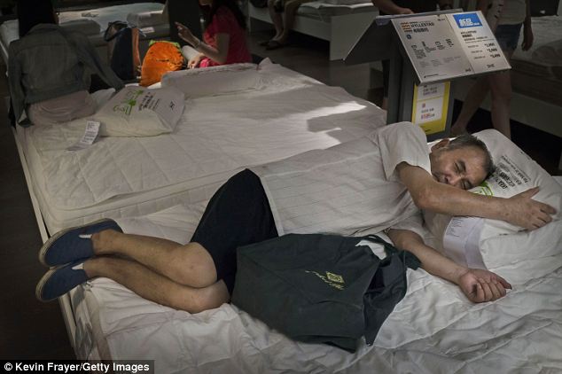 Desperate for some rest: This shopper doesn't care that the bed he's sleeping on has not yet been made