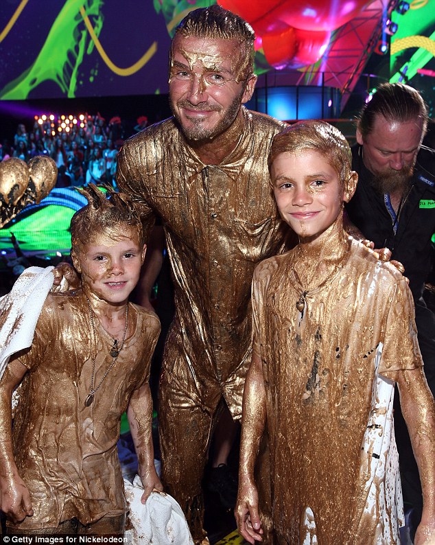 Chips off the old block: The kids managed to raise a smile like pros for the cameras after their sliming