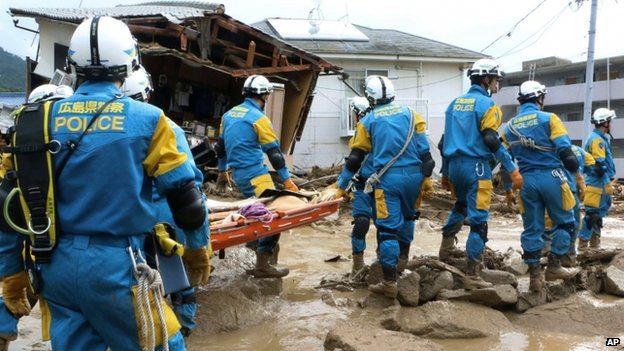 A troop of police rescue personnel head out for rescue operations after a massive landslide swept through a residential area in Hiroshima, western Japan, on 20 August 2014