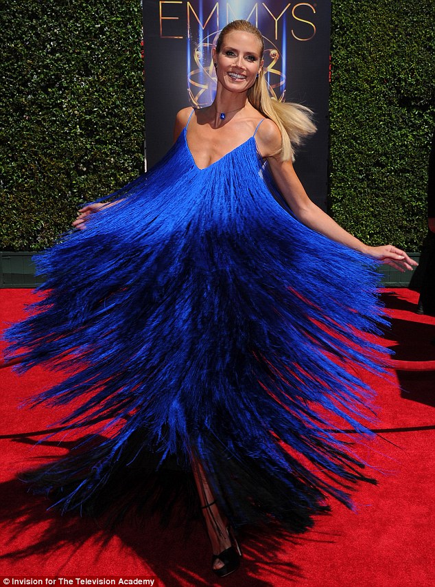 Up and away: Heidi Klum wore a loud royal blue dress for her turn on the Creative Arts Emmy Awards red carpet on Saturday in Los Angeles, which was made from tiny strings that frayed out like a peacock when she twirled