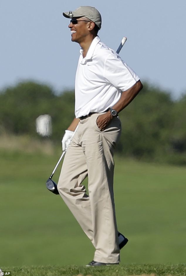President Barack Obama, right, smiles while golfing at Vineyard Golf Club on the island of Martha's Vineyard straight after delivering an emotive speech about the beheading of US journalist James Foley