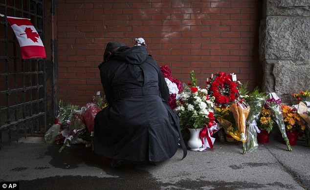 A man lays flowers at the memorial outside John Weir Foote Armory, where Cpl Cirillo was stationed