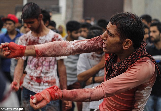 Men were seen drenched in blood as they observed the tradition, as hundreds of onlookers watched