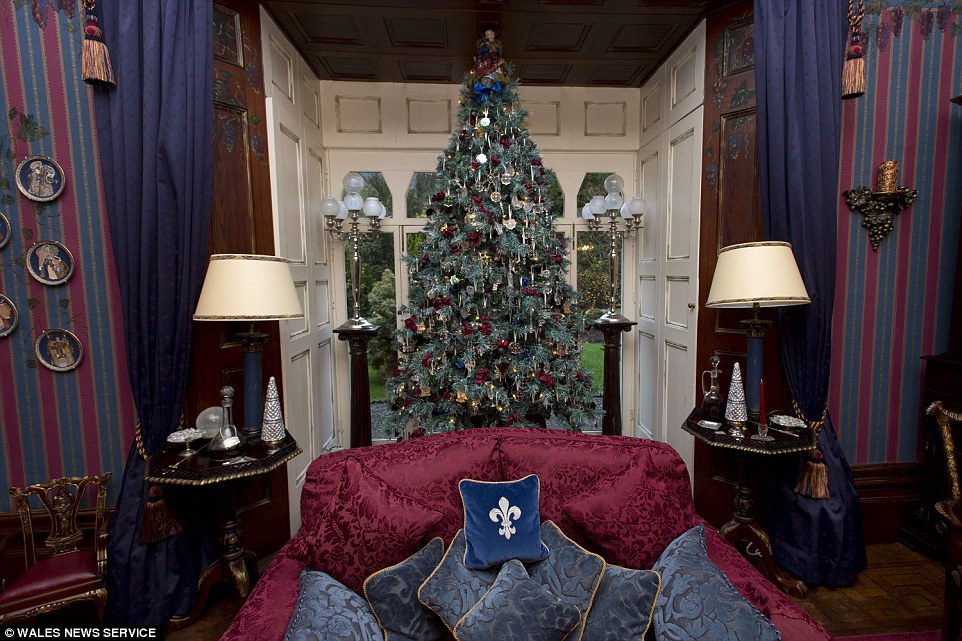 A shimmering crystal tree is decorated along the same royal blue and purple scheme as the living room it is in
