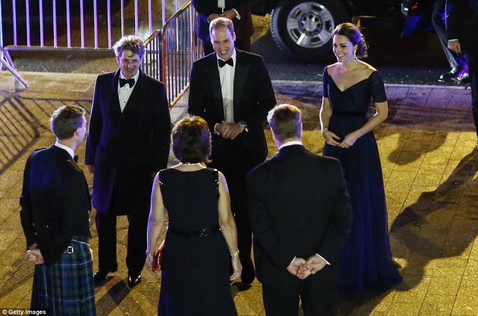 Not affected by the weather: William and Kate - who expecting their second child in April next year- beam as they speak to other guests