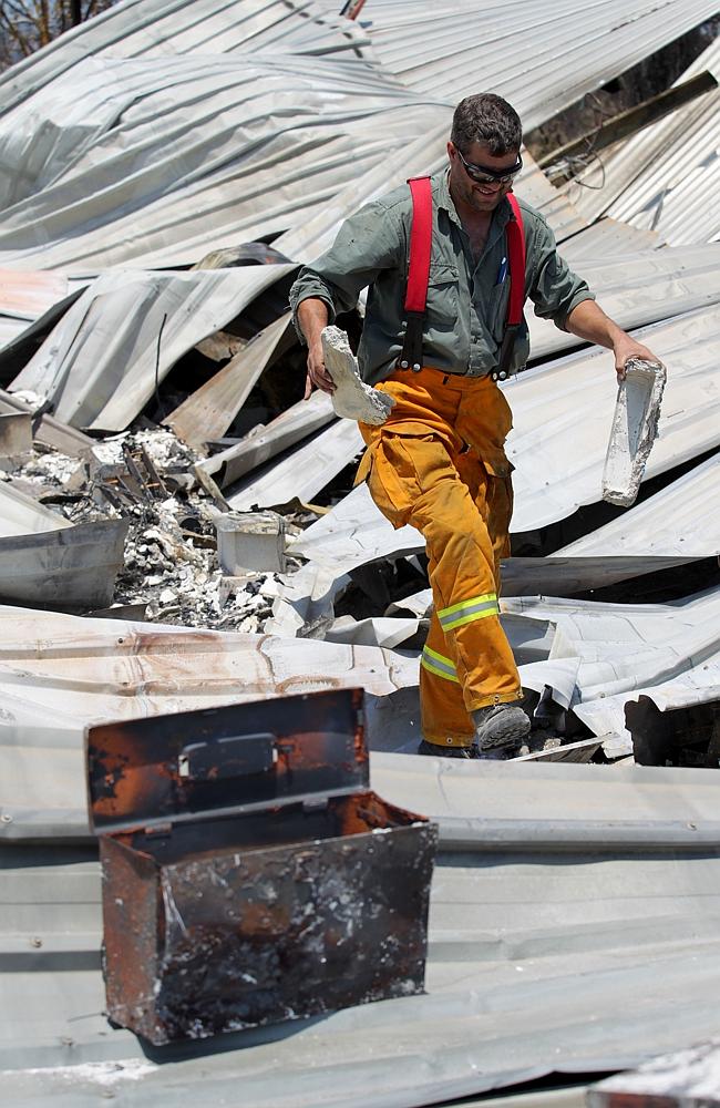 Sifting through the remains ... Ben Whiteway holds the remains of his fire proof safe.His