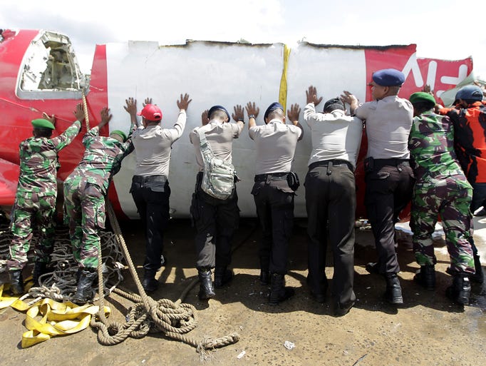 Indonesian officials move the tail of the aircraft