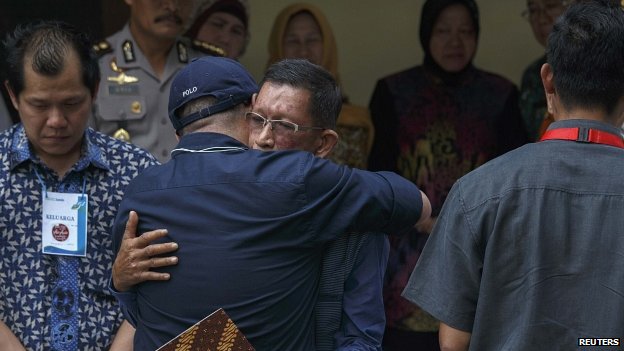AirAsia representatives hug relatives of crash passengers who are at Bhayankara Hospital in Surabaya to receive their remains 02/01/2015