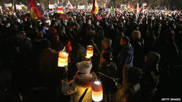 Supporters of the Pegida movement, including some holding lanterns glowing in the colours of the German flag, gather for another of their weekly protests on January 5, 2015 in Germany