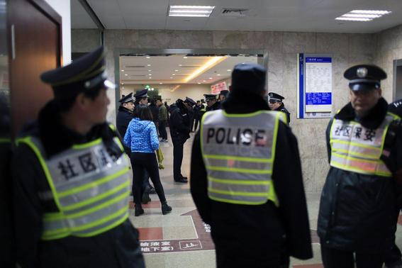 Security personnel (front) and policemen stand next to an entrance to a hospital where injured people of a stampede incident are treated, in Shanghai, January 1, 2015. REUTERS-Aly Song
