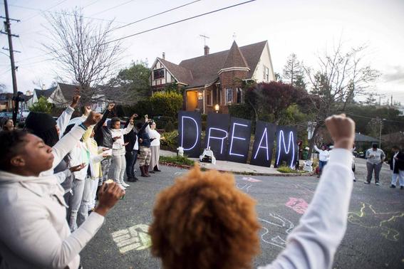 Black rights protesters gather near illuminated letters spelling 'DREAM' outside a house which they identified as the residence of Oakland Mayor Libby Schaaf, in Oakland, California January 19, 2015.  REUTERS-Noah Berger
