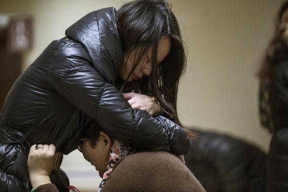 Relatives of a victim hug as they wait at a hospital where injured people of a stampede incident are treated in Shanghai January 1, 2015. REUTERS-Aly Song