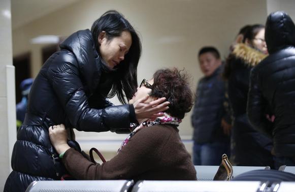 Relatives of a victim hug as they wait at a hospital where injured people of a stampede incident are treated in Shanghai January 1, 2015. REUTERS-Aly Song