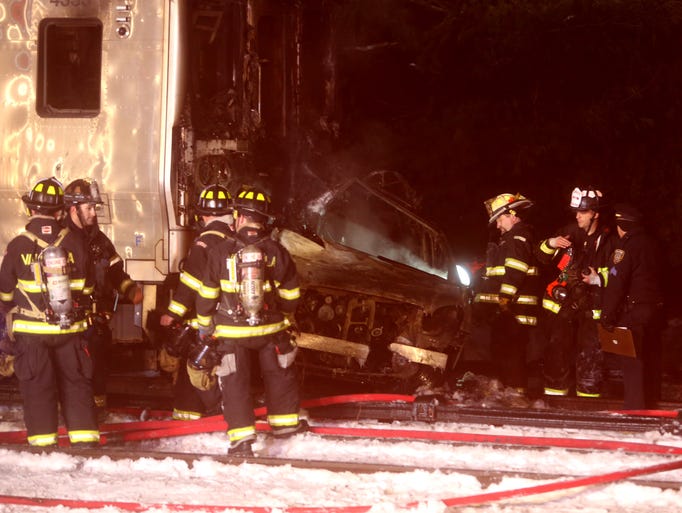 Firefighters work at the scene of a train vs car accident