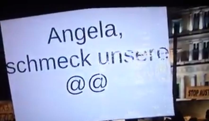 Το πλακάτ για τη Μέρκελ που άφησε άφωνη τη ρεπόρτερ – ΒΙΝΤΕΟ