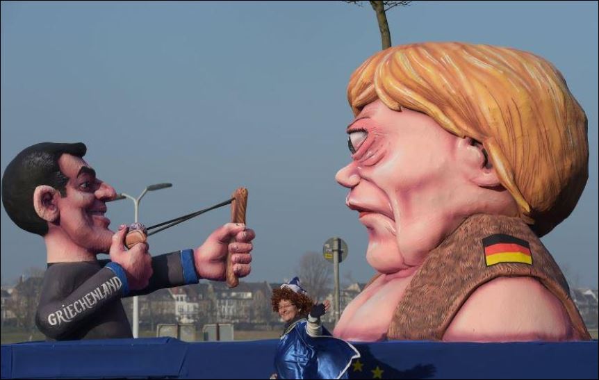 Η Μέρκελ “Γολιάθ” και ο Τσίπρας με σφεντόνα στο καρναβάλι της Κολωνίας – ΦΩΤΟ