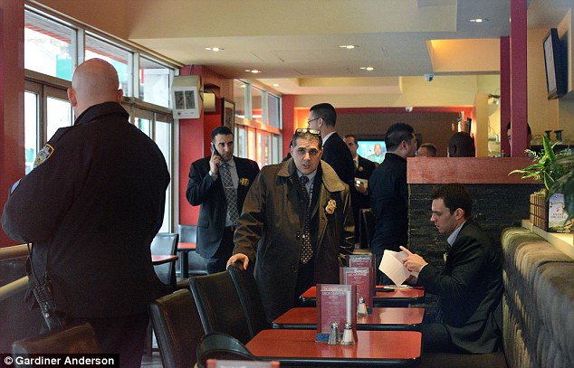 A woman who walked into the bathroom Monday afternoon says she saw Fisher with her hand over the baby's mouth, saying she was trying to 'make him go to sleep'. Above, investigators inside the restaurant on Monday