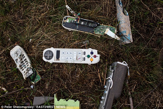 Grim: Alongside Mabel's passport, many small parts from the plane - such as controllers for the in-flight entertainment systems - are visible among MH17's charred detritus