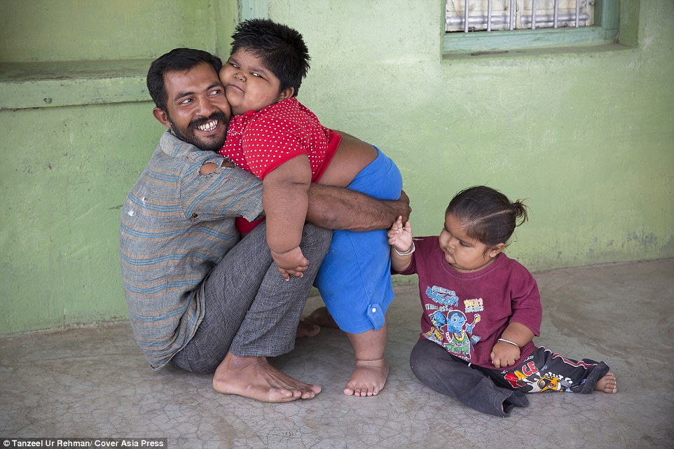 Hard-working: Anisha hugs her father Rameshbhai, with Harsh. Mr Nandwana spends about Rs 10,000 (£110) a month on food for his children