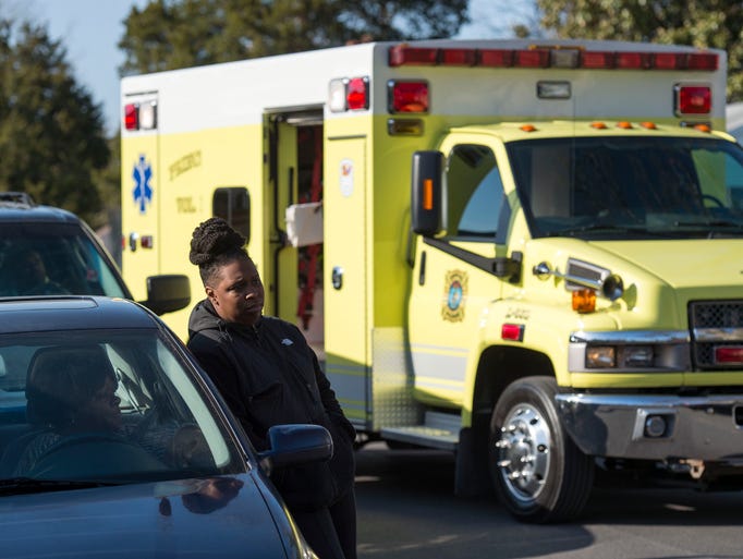Onlookers gather outside of an Antioch Ave house, where