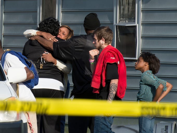 Onlookers react as bodies are removed from an Antioch