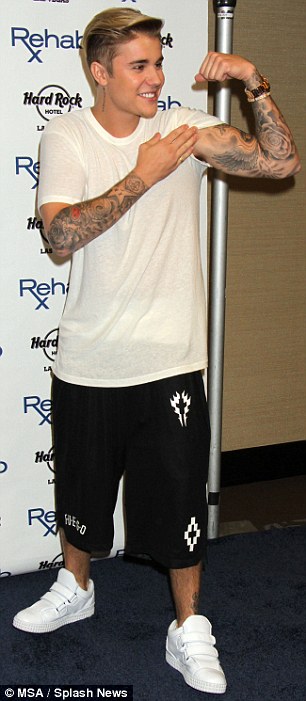 Strong man: Justin showed off his bicep and lifts his shirt as he hosted a pre-fight party at the Rehab Pool inside the Hard Rock Hotel and Casino