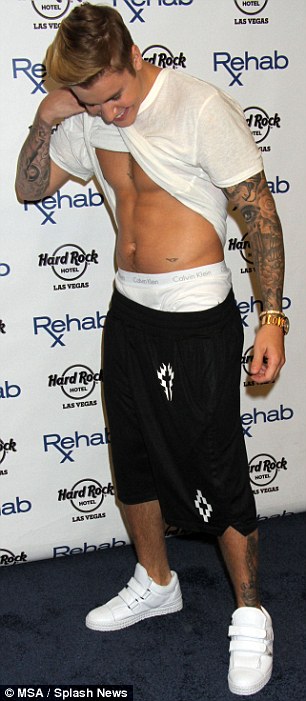 Strong man: Justin showed off his bicep and lifts his shirt as he hosted a pre-fight party at the Rehab Pool inside the Hard Rock Hotel and Casino