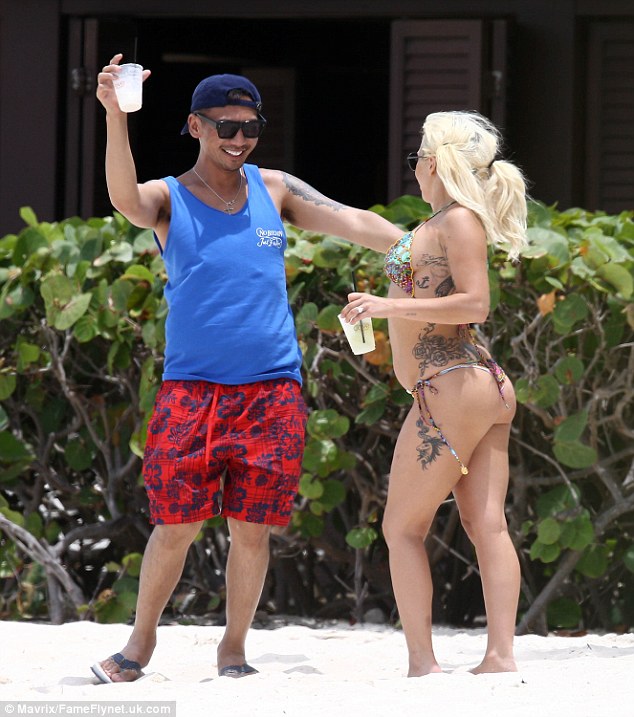 What a performer: The singer laughed as her friend threw some shapes on the sand