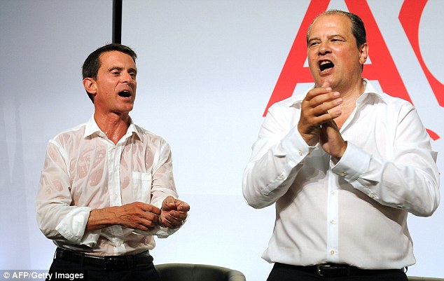 First secretary of the French left-wing Socialist Party Jean-Christophe Cambadelis (right) and French Prime Minister Manuel Valls applaud after Valls delivered his speech