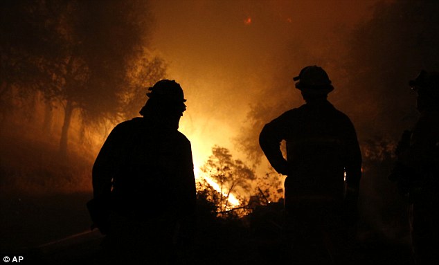 Firefighters watch as the flames of the Butte Fire approach a containment line near San Andreas