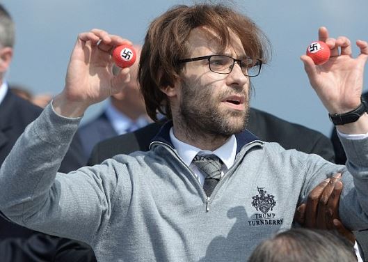 Βρετανός κωμικός διέκοψε την ομιλία του Τραμπ – Μοίραζε μπαλάκια του γκολφ με σβάστικες – ΒΙΝΤΕΟ