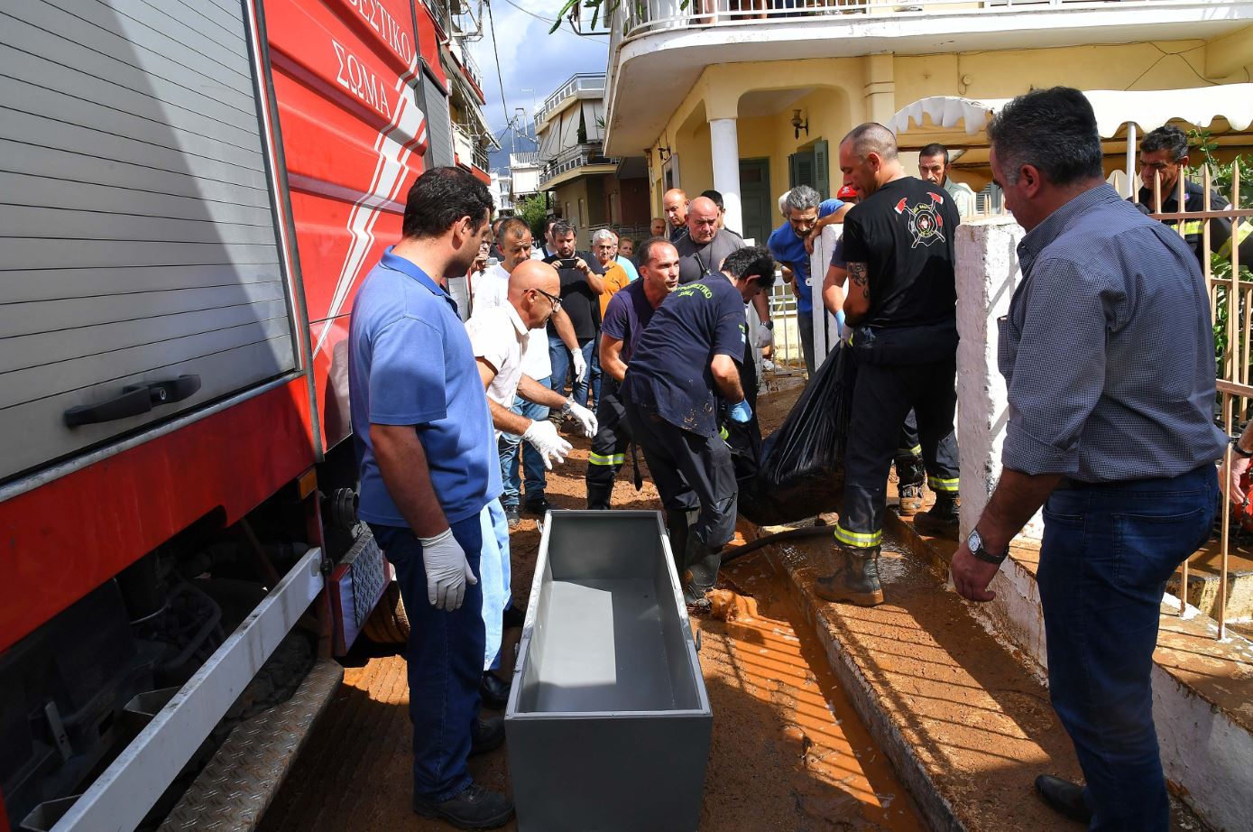 Καλαμάτα – Πυροσβέστες μεταφέρουν τη σορό γυναίκας που βρέθηκε πνιγμένη σε υπόγειο σπιτιού – ΦΩΤΟ