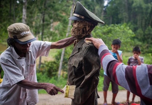 Relatives clean the body of L Sarungu (L), an army veteran dead for 10 years, during the Ma'nene ritual at Panggala Village on August 25, 2016 in Toraja, Indonesia.