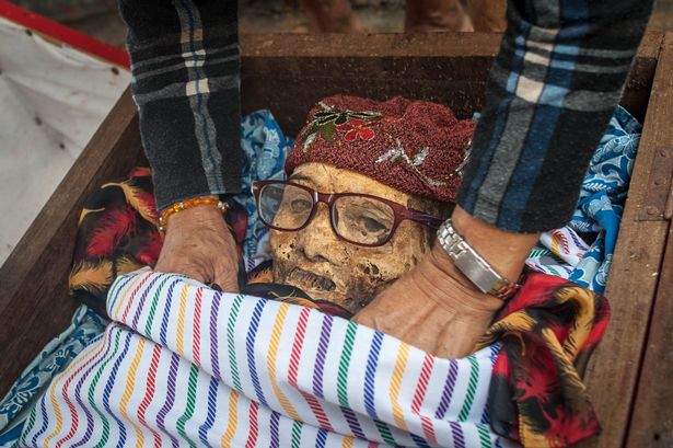 Relatives clean the body of Ne'Tampo, dead for 30 years, during the Ma'nene ritual at Panggala Village on August 26, 2016 in Toraja, Indonesia.