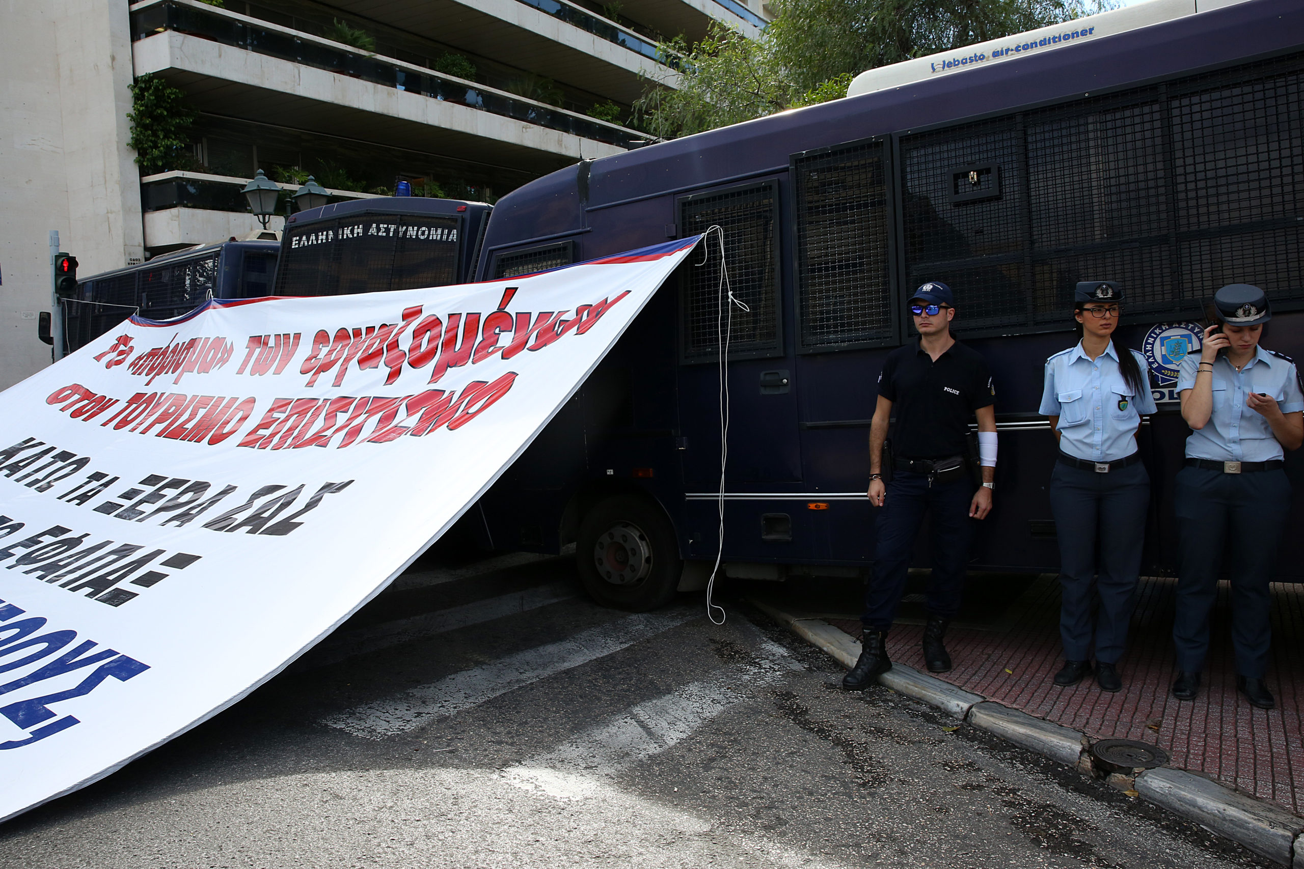 Το πανό που κρέμασαν στις κλούβες των ΜΑΤ οι ξενοδοχοϋπάλληλοι – ΦΩΤΟ