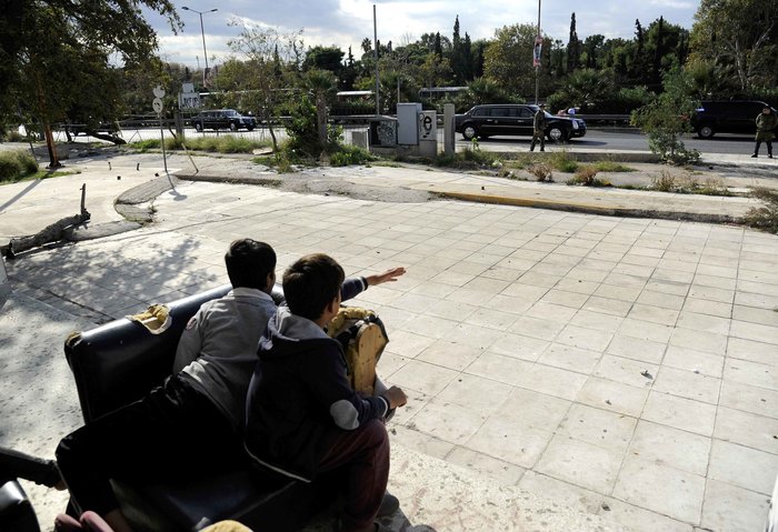 Παιδιά-πρόσφυγες παρακολουθούν την αυτοκινητοπομπή του Ομπάμα – ΦΩΤΟ