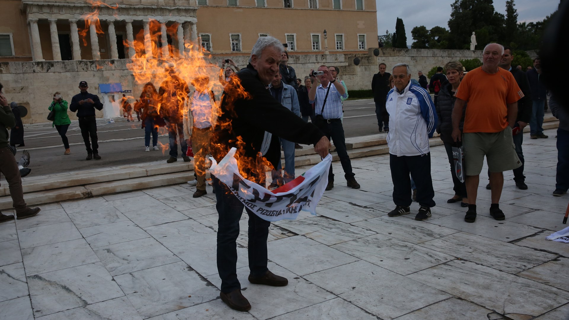 Καίνε σημαίες του ΣΥΡΙΖΑ έξω από τη Βουλή – ΦΩΤΟ