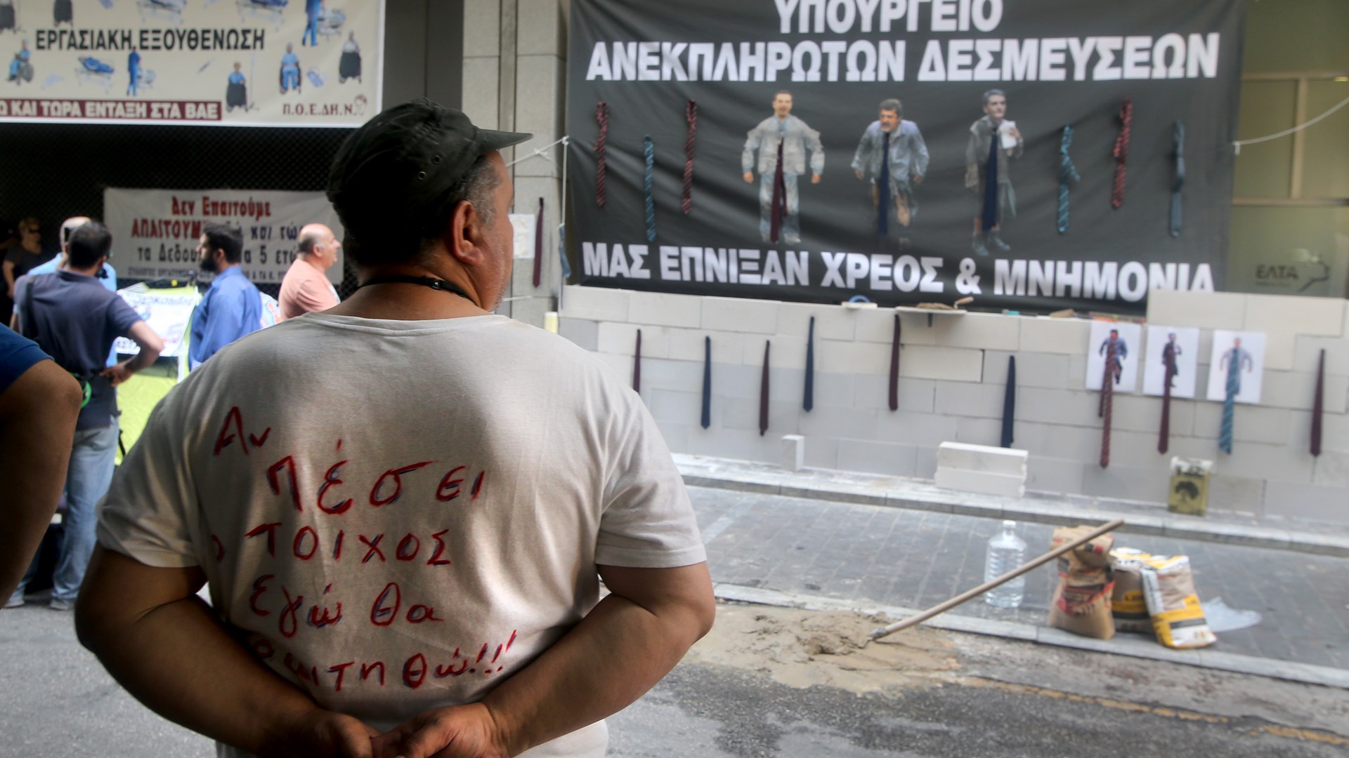 Ο τοίχος που “έχτισε” η ΠΟΕΔΗΝ στην είσοδο του υπουργείου Οικονομικών και το πανό με τις γραβάτες – ΦΩΤΟ