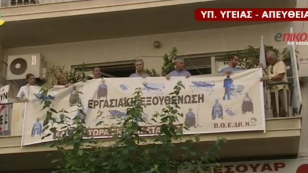 Με πανό υποδέχονται τα μέλη της ΠΟΕΔΗΝ τον Πρωθυπουργό – ΒΙΝΤΕΟ