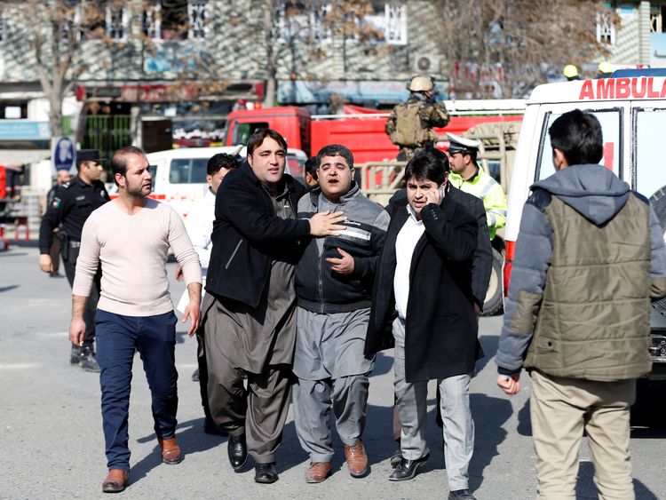 People assist an injured man after a blast in Kabul, Afghanistan January 27, 2018