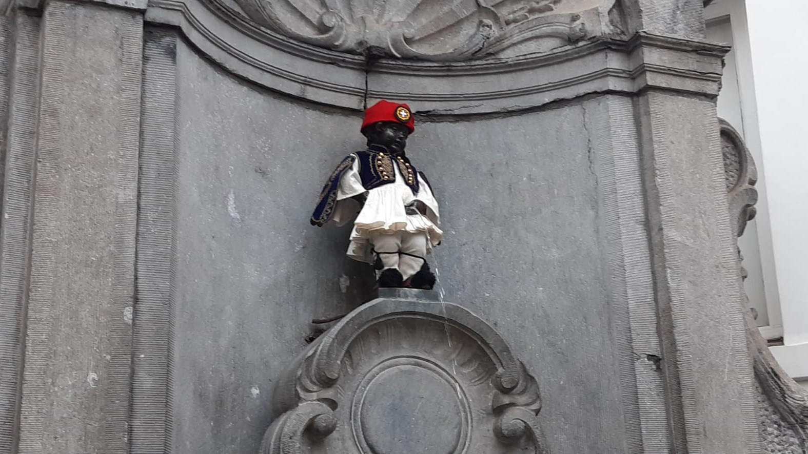 Βρυξέλλες: Ντύθηκε εύζωνας το διάσημο αγαλματάκι Manneken Pis – ΦΩΤΟ