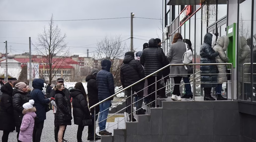 Πολίτες περιμένουν στην ουρά σε ATM στο Lviv της Ουκρανίας (Reuters)