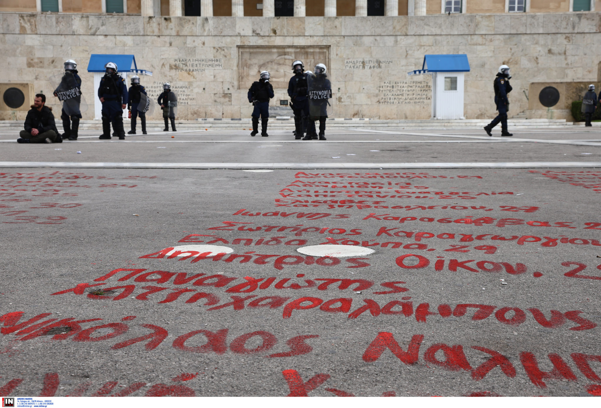 Οι συγκεντρωμένοι γράφουν τα 57 ονόματα των θυμάτων των Τεμπών μπροστά από το μνημείο του Αγνώστου Στρατιώτη.